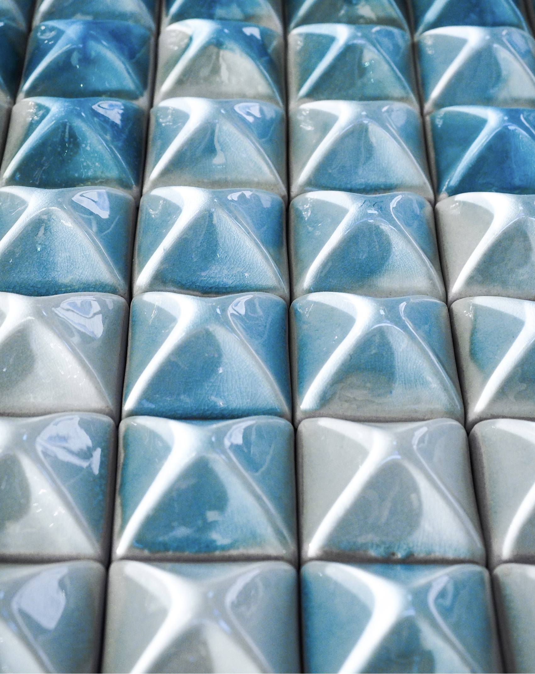 Raised surface is glazed with naturally graded blue